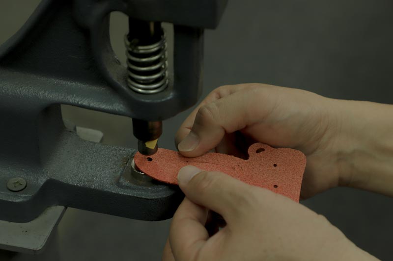 革に機械で穴を空けている様子